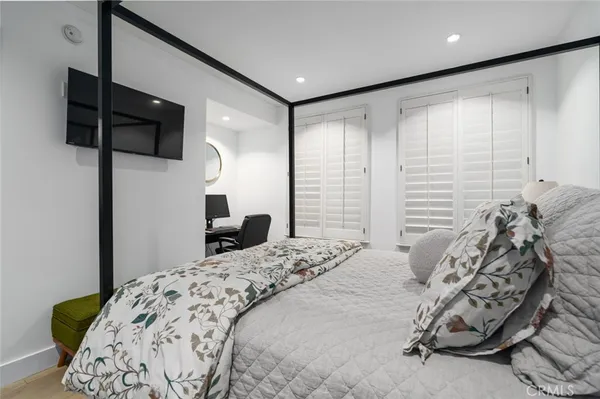 a bedroom with a bed window and a flat screen tv