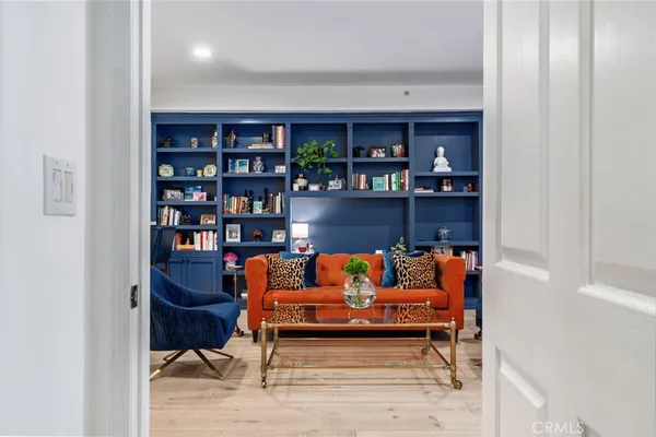a living room with furniture a rug and a book shelf