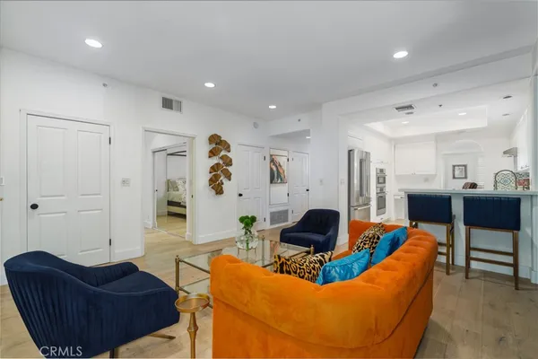 a living room with furniture and a view of kitchen