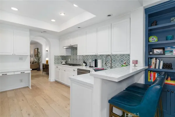 a kitchen with cabinets and wooden floor