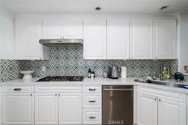 a kitchen with white cabinets and sink