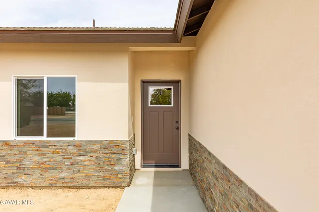 a large kitchen with stainless steel appliances a large counter top a stove a sink and a large window