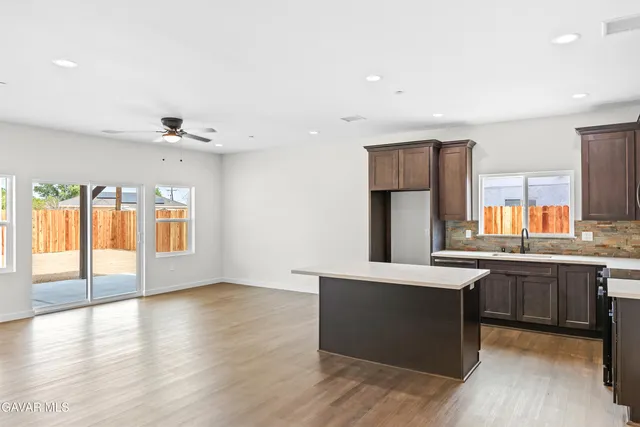 a kitchen with stainless steel appliances granite countertop a sink and a wooden floor