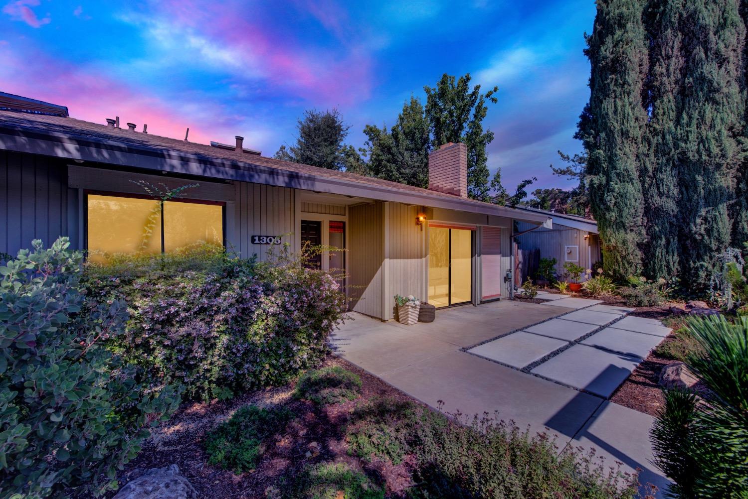 a front view of a house with a yard and a garden
