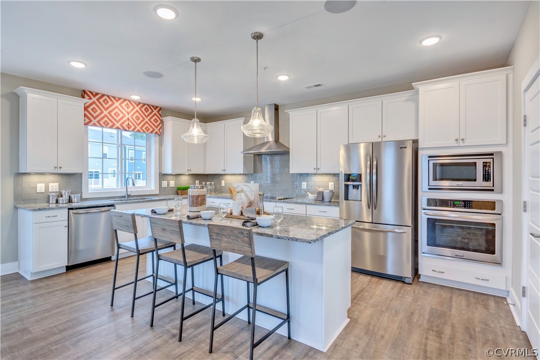 4359 Saunders Station Loop, Unit B Richmond, VA 23233 - Photo 14 of 31 a kitchen with stainless steel appliances granite countertop a refrigerator a sink dishwasher a stove and white cabinets with wooden floor