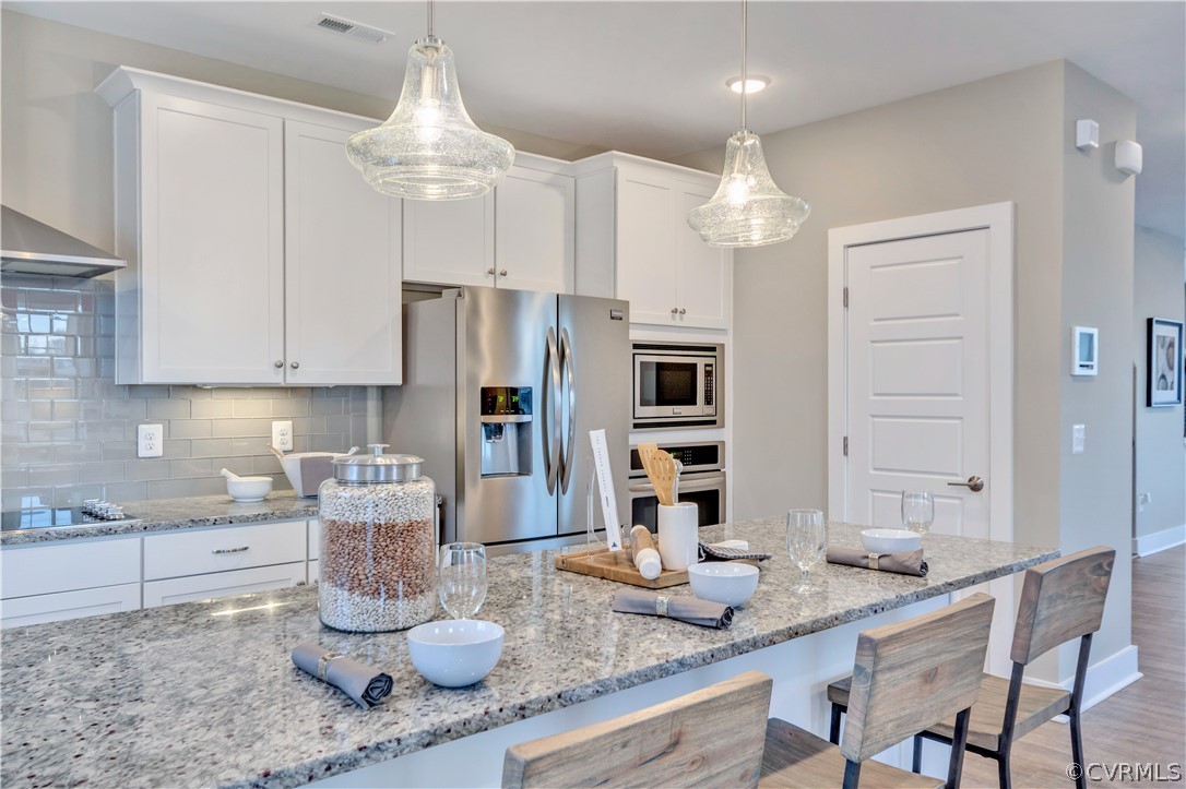 4359 Saunders Station Loop, Unit B Richmond, VA 23233 - Photo 17 of 31 a kitchen with granite countertop a sink a center island cabinets and stainless steel appliances