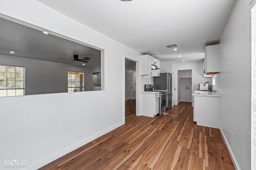 3407 Hickory Ridge Road Shreveport, LA 71108 - Photo 14 of 35 Kitchen with light countertops, white cabinets, dark wood-type flooring, stainless steel electric stove, and a ceiling fan