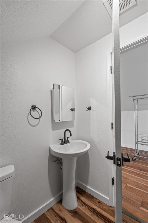 3407 Hickory Ridge Road Shreveport, LA 71108 - Photo 23 of 35 Bathroom featuring wood finished floors, a textured ceiling, and a textured wall