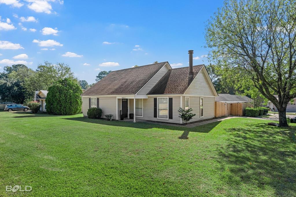 3407 Hickory Ridge Road Shreveport, LA 71108 - Photo 4 of 35 View of front of home featuring a front yard, a shingled roof, and a patio area