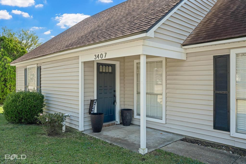 3407 Hickory Ridge Road Shreveport, LA 71108 - Photo 5 of 35 View of exterior entry featuring roof with shingles and a yard
