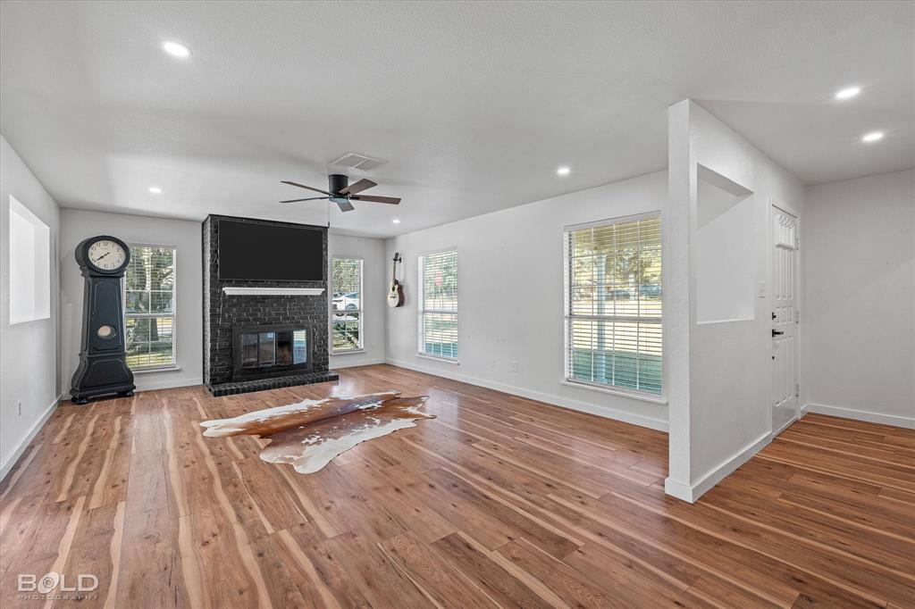 3407 Hickory Ridge Road Shreveport, LA 71108 - Photo 8 of 35 Unfurnished living room with healthy amount of natural light, wood finished floors, recessed lighting, a fireplace, and ceiling fan