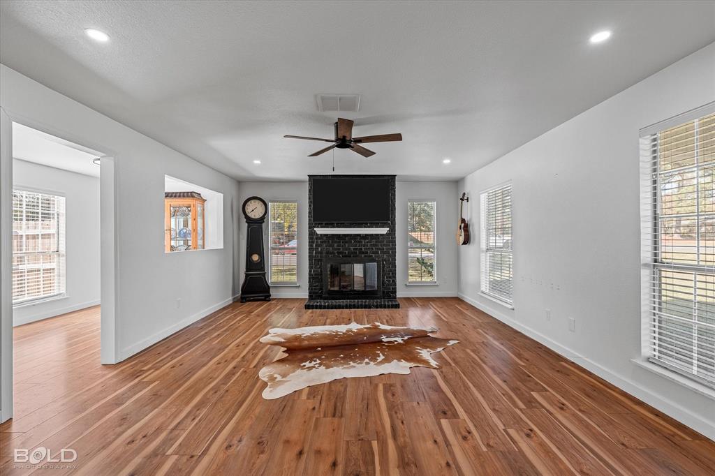 3407 Hickory Ridge Road Shreveport, LA 71108 - Photo 9 of 35 Unfurnished living room with a brick fireplace, ceiling fan, recessed lighting, and wood finished floors