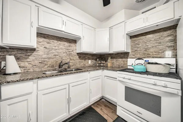 a kitchen with stainless steel appliances granite countertop a refrigerator and a stove top oven