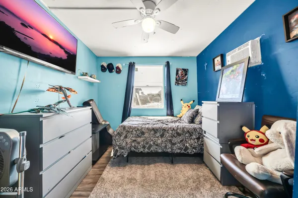 a bedroom with a bed dresser and flat screen tv