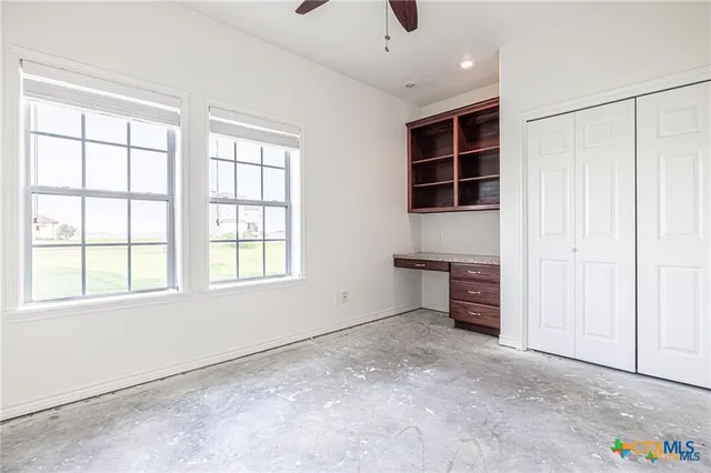 an empty room with windows and cabinet