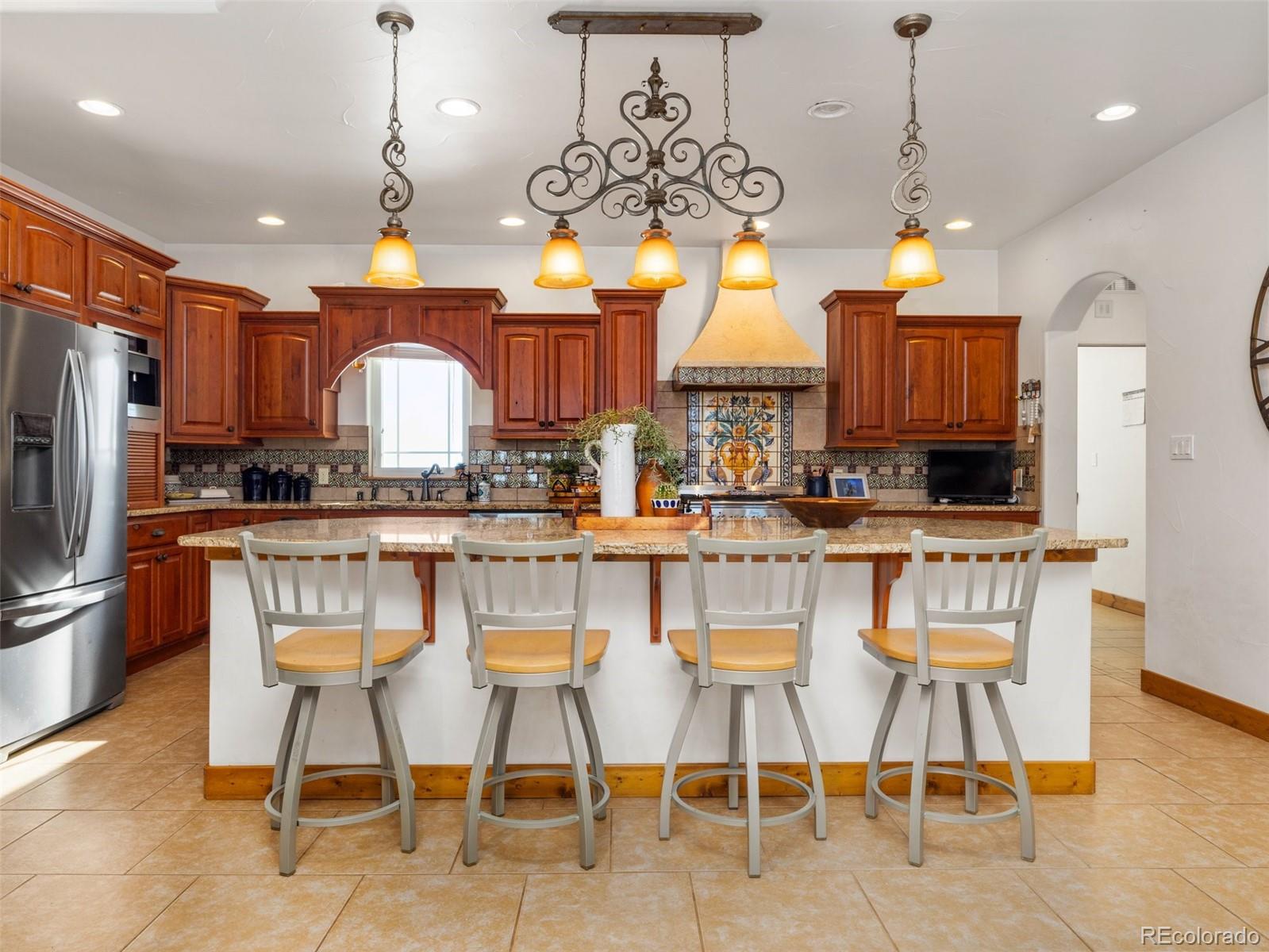 8760 Ridge Road Beulah, CO 81023 - Photo 16 of 49 a kitchen with stainless steel appliances granite countertop a sink a stove a refrigerator cabinets and chairs