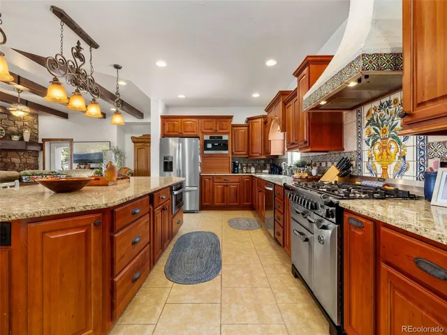 a kitchen with stainless steel appliances granite countertop a sink a stove and a wooden cabinets