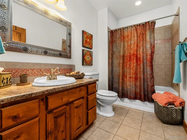 a bathroom with a granite countertop sink toilet mirror and shower
