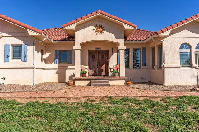 a view of a house with large windows and a table and chairs
