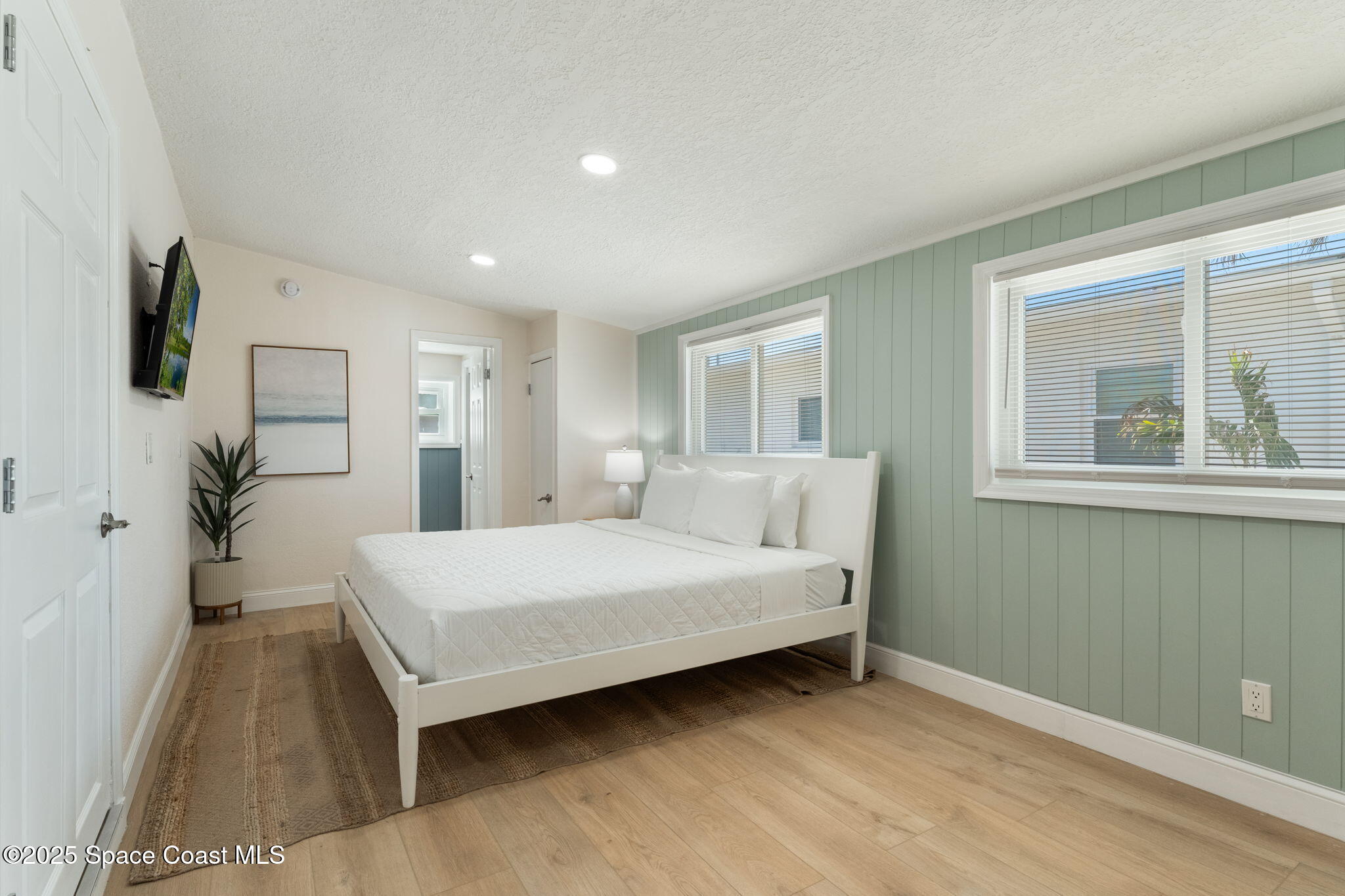 637 South Orlando Avenue Cocoa Beach, FL 32931 - Photo 11 of 83 a room with a bed and a potted plant