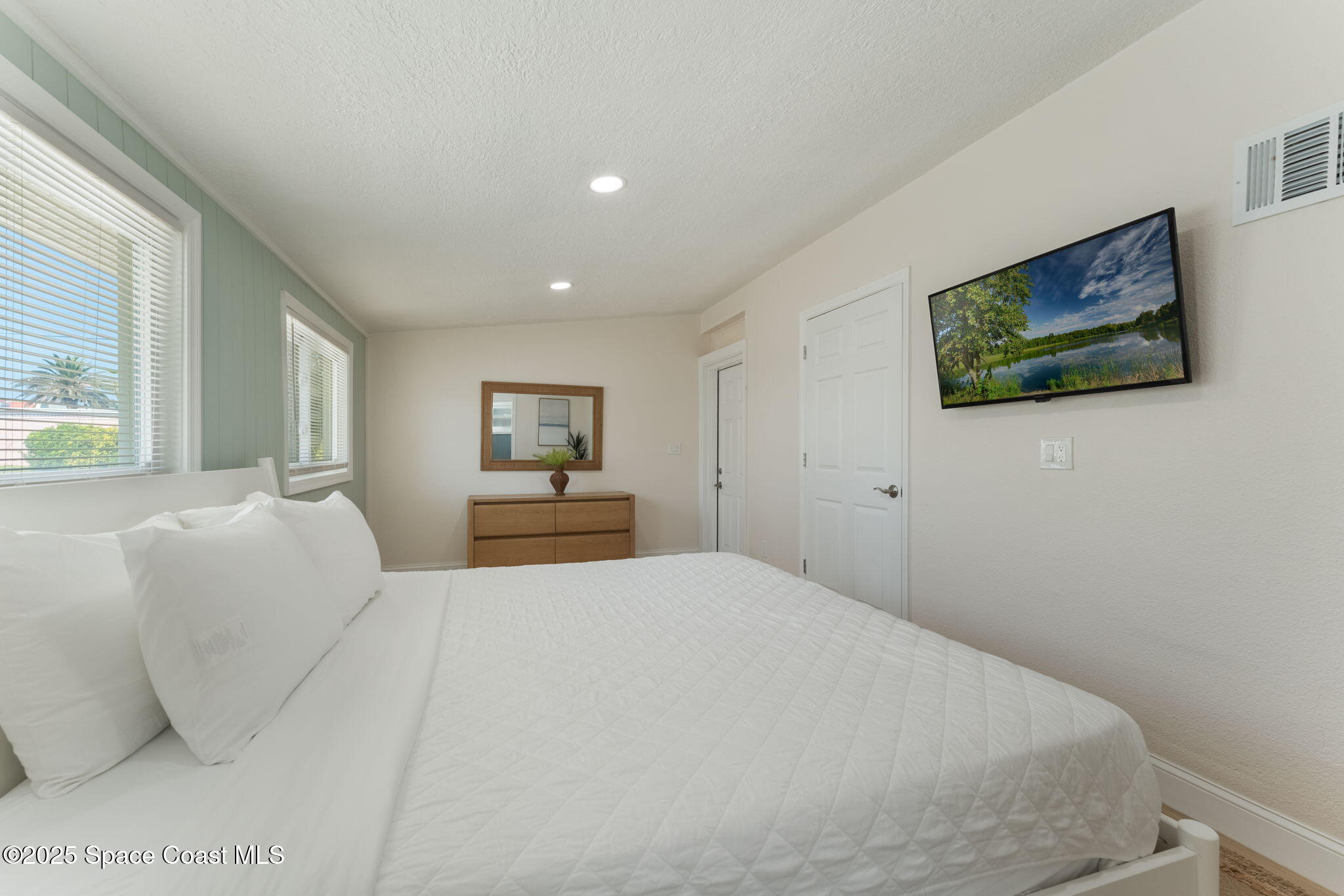 637 South Orlando Avenue Cocoa Beach, FL 32931 - Photo 12 of 83 a large bedroom with a bed and a painting on the wall