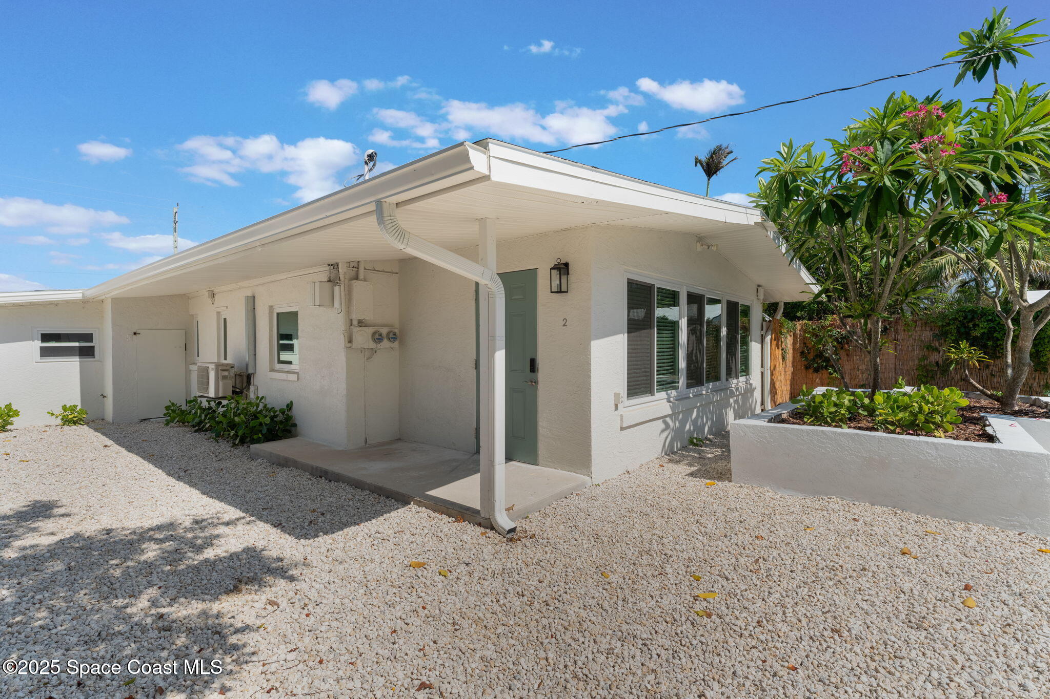 637 South Orlando Avenue Cocoa Beach, FL 32931 - Photo 16 of 83 a view of a white house with a yard and potted plants