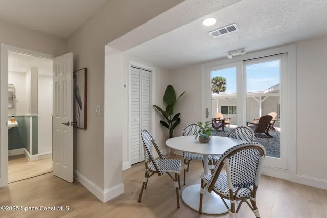 a living room with stainless steel appliances furniture a rug and a kitchen view