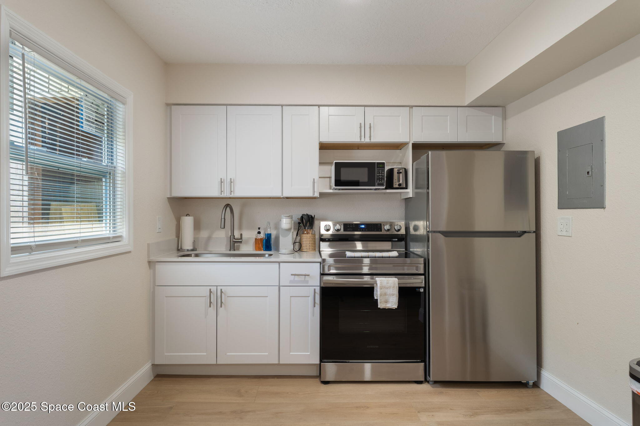 637 South Orlando Avenue Cocoa Beach, FL 32931 - Photo 41 of 83 a kitchen with stainless steel appliances granite countertop a refrigerator a stove a sink and a microwave