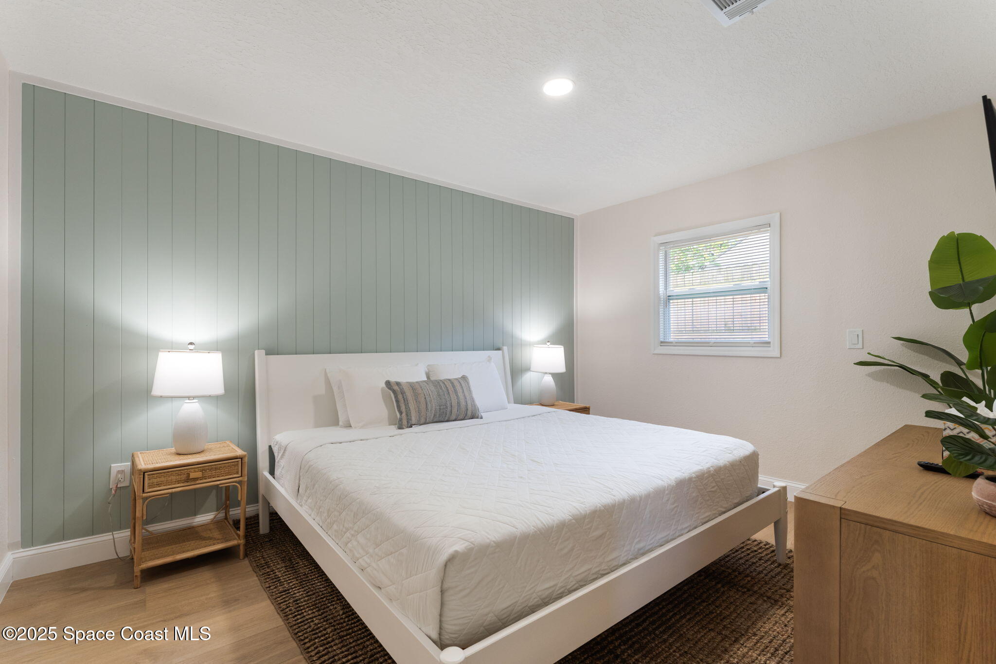 637 South Orlando Avenue Cocoa Beach, FL 32931 - Photo 43 of 83 a bedroom with a bed and a dresser next to a window