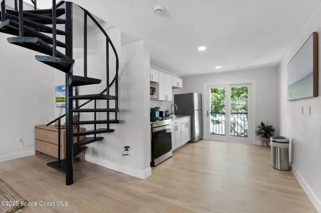 a view of a patio with table and chairs potted plants and large tree