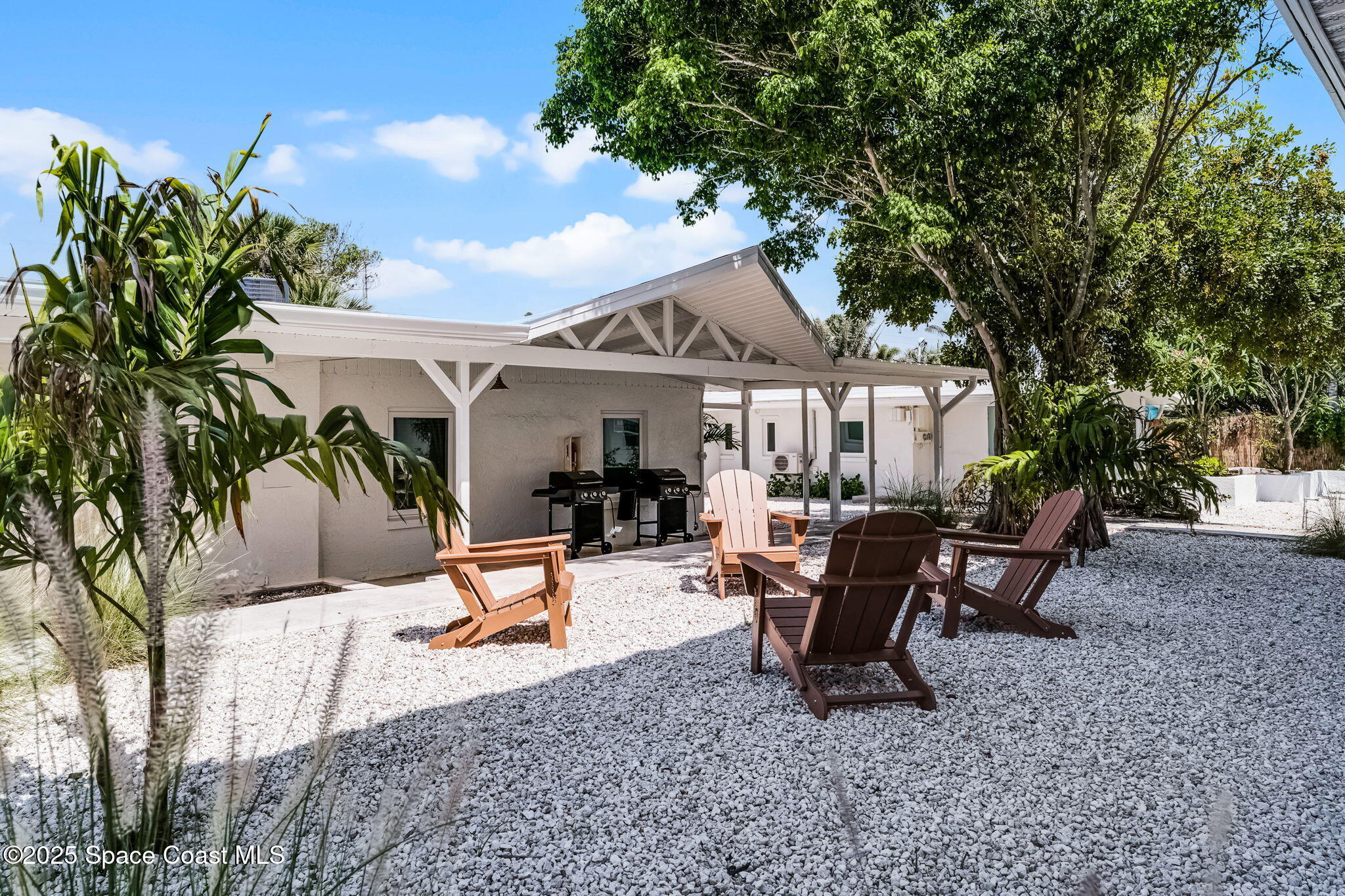 637 South Orlando Avenue Cocoa Beach, FL 32931 - Photo 79 of 83 a view of a patio with table and chairs potted plants and large tree