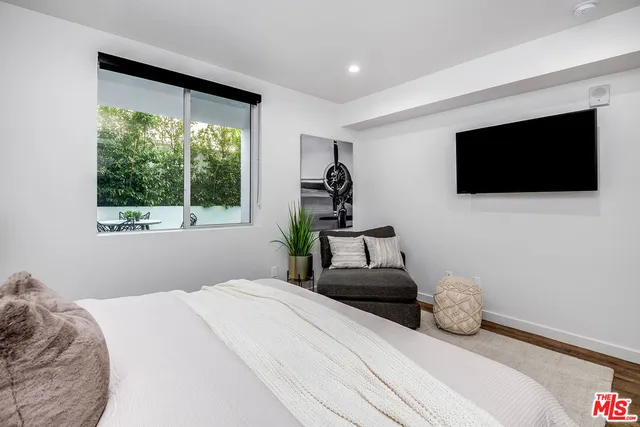 a bedroom with a bed and a flat screen tv