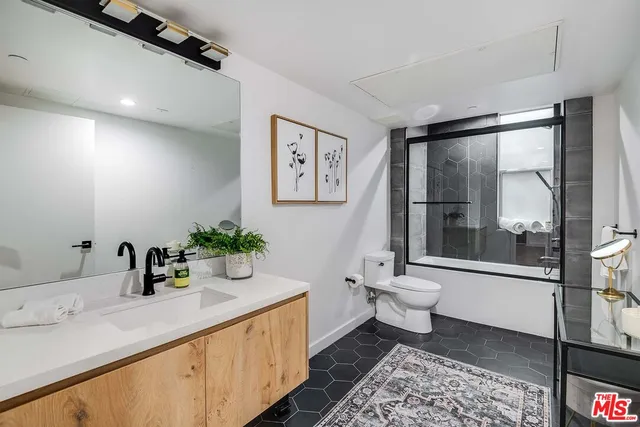 a bathroom with a double vanity sink toilet and shower