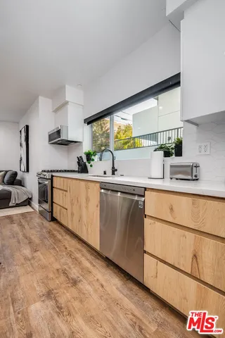 a kitchen with stainless steel appliances granite countertop a sink and a stove