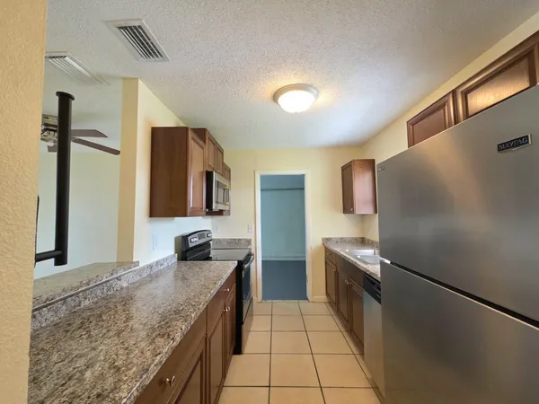 a kitchen with granite countertop a sink and stainless steel appliances