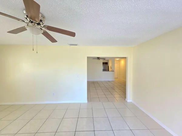 an empty room with a ceiling fan and a window