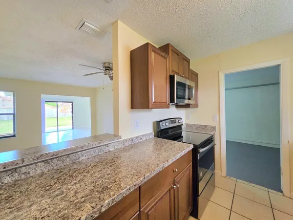 a kitchen with granite countertop cabinets stainless steel appliances and a counter space