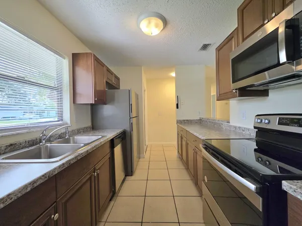 a kitchen with stainless steel appliances granite countertop a sink and a stove