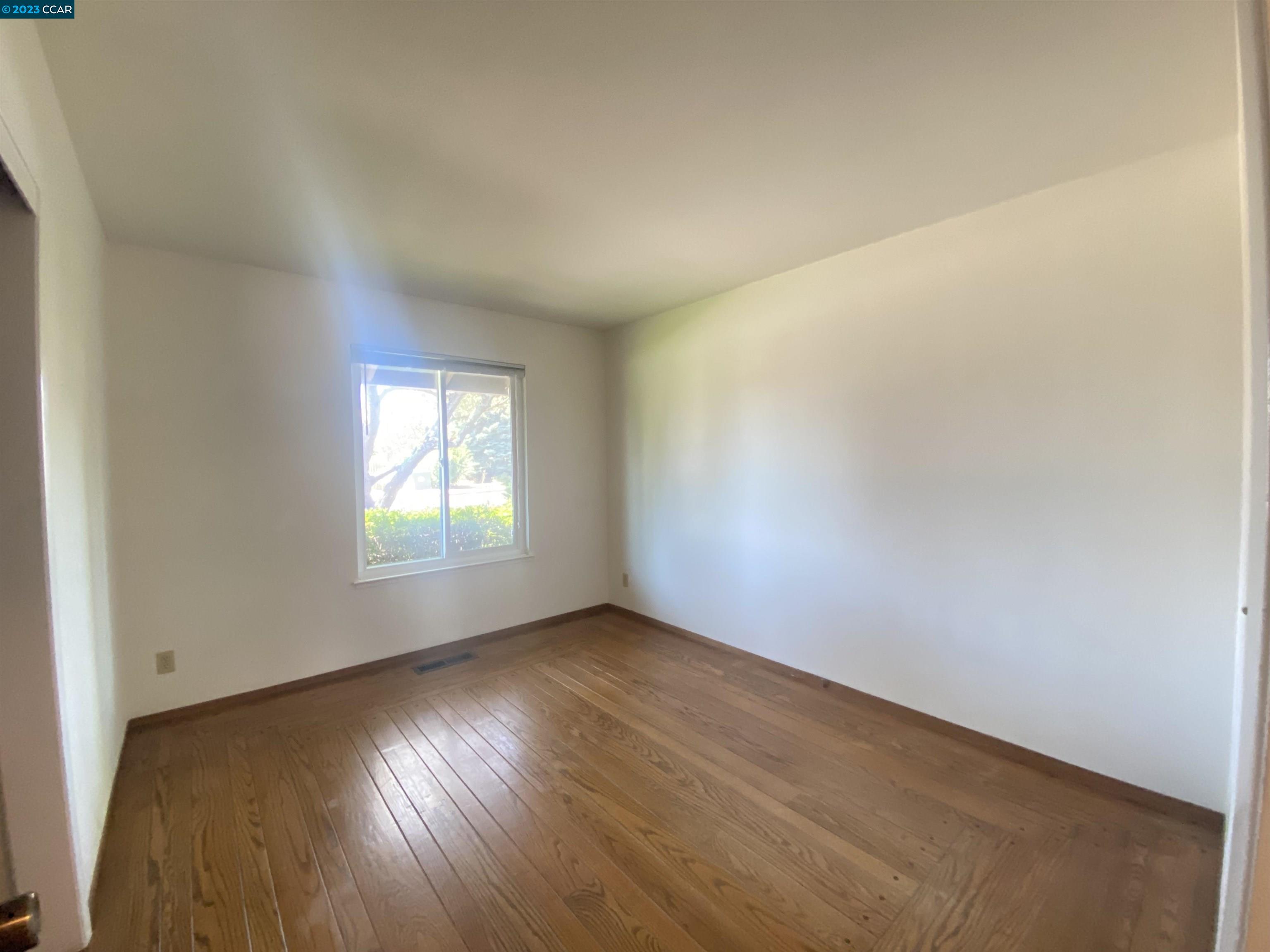 269 Birchwood Drive Moraga, CA 94556 - Photo 28 of 43 an empty room with wooden floor and windows