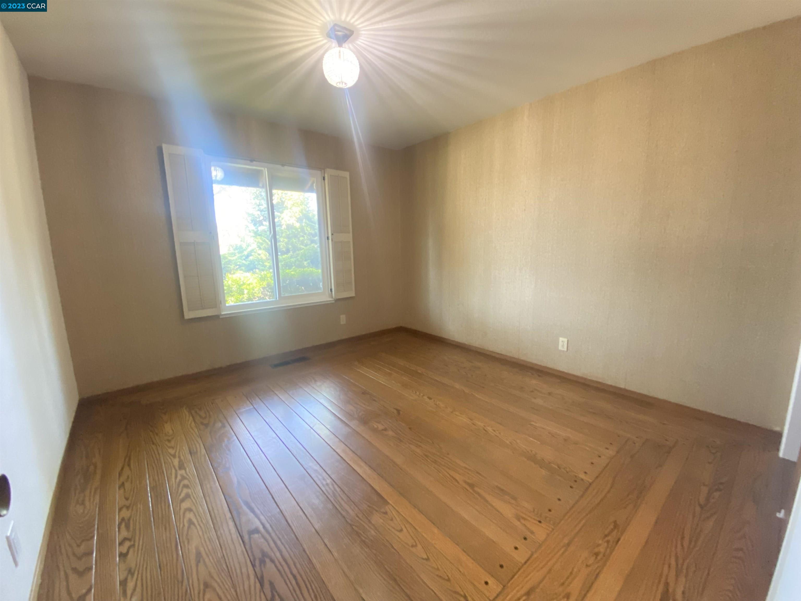 269 Birchwood Drive Moraga, CA 94556 - Photo 30 of 43 an empty room with wooden floor and windows