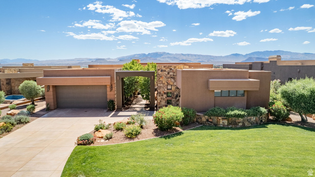 2331 West Entrada Trail, Unit 61 St. George, UT 84770 - Photo 60 of 69 Contemporary stucco exterior featuring a stone accent wall, integrated two-car garage, and a concrete driveway