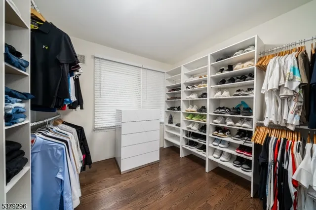 a view of walk in closet with clothes and shoes