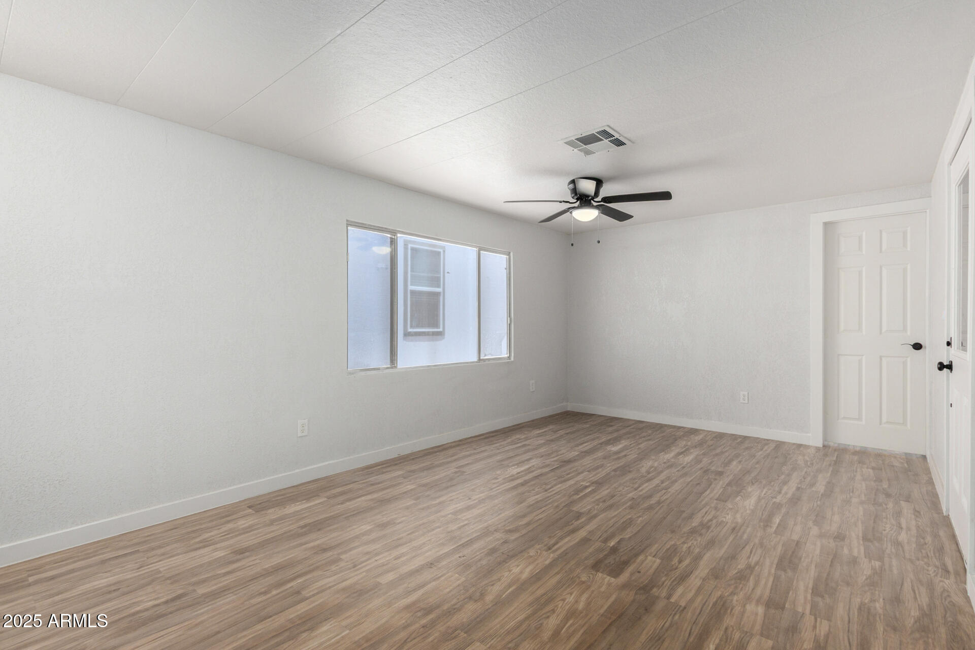 2050 West Dunlap Avenue, Unit D42 Phoenix, AZ 85021 - Photo 19 of 30 wooden floor in an empty room with a window