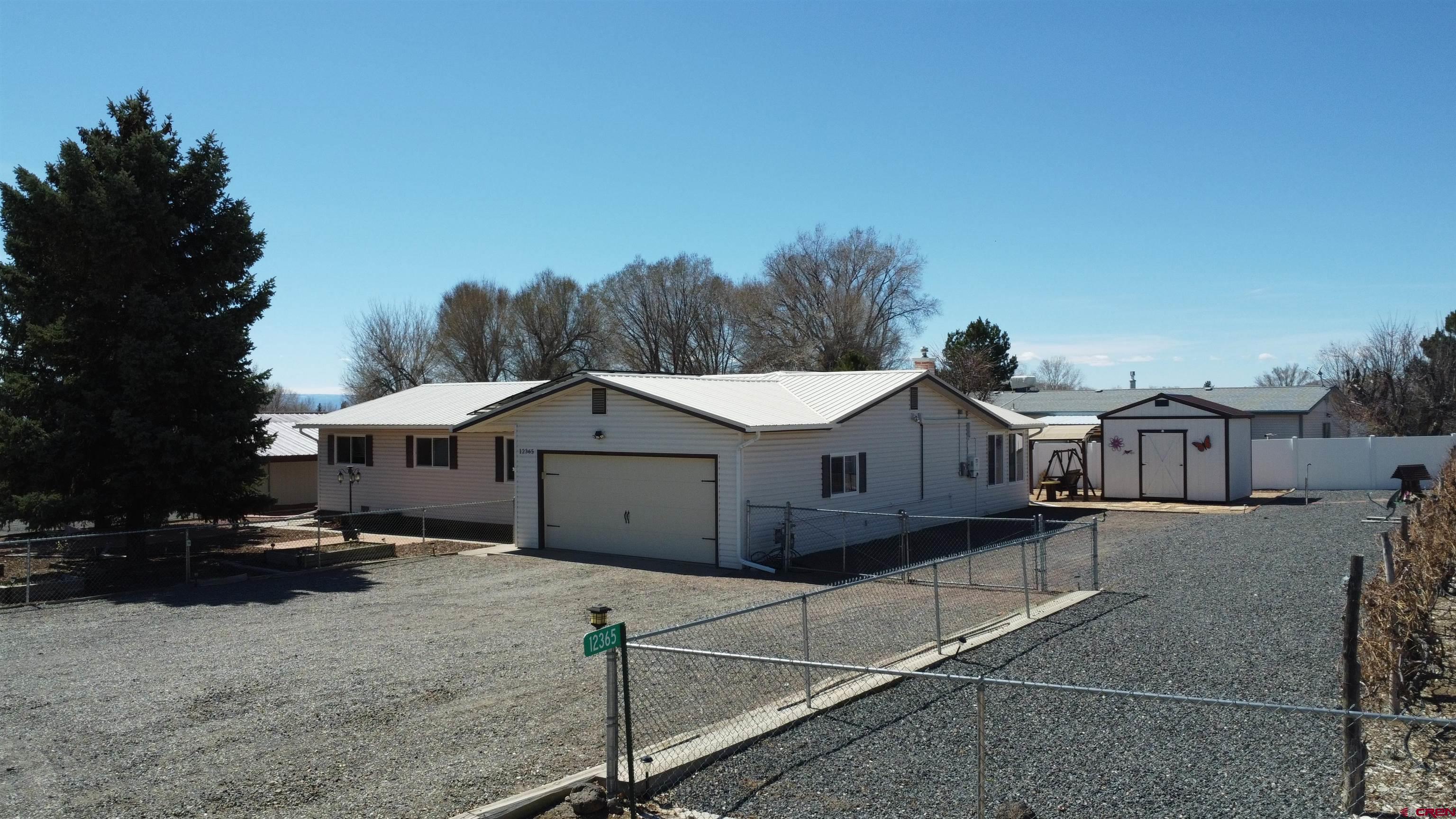12365 East Spring Circle Eckert, CO 81418 - Photo 25 of 34 a view of a white house that has a small yard and large tree