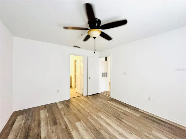 an empty room with a window and a fan