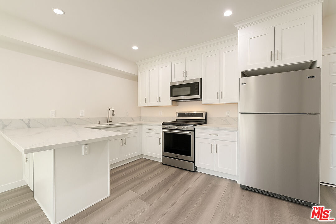 5244 Whitsett Avenue, Unit 1/4 Valley Village, CA 91607 - Photo 2 of 13 a kitchen with a refrigerator stove and sink