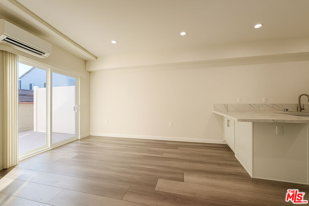 5244 Whitsett Avenue, Unit 1/4 Valley Village, CA 91607 - Photo 3 of 13 a view of an empty room with wooden floor and a window