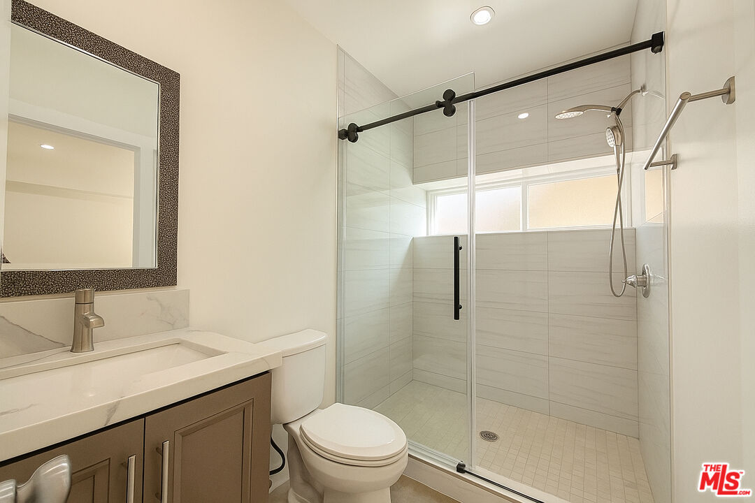 5244 Whitsett Avenue, Unit 1/4 Valley Village, CA 91607 - Photo 4 of 13 a bathroom with a shower sink vanity mirror and toilet