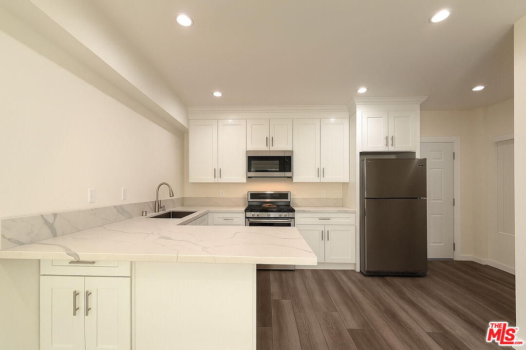 5244 Whitsett Avenue, Unit 1/4 Valley Village, CA 91607 - Photo 7 of 13 a kitchen with a sink a stove a refrigerator and a refrigerator