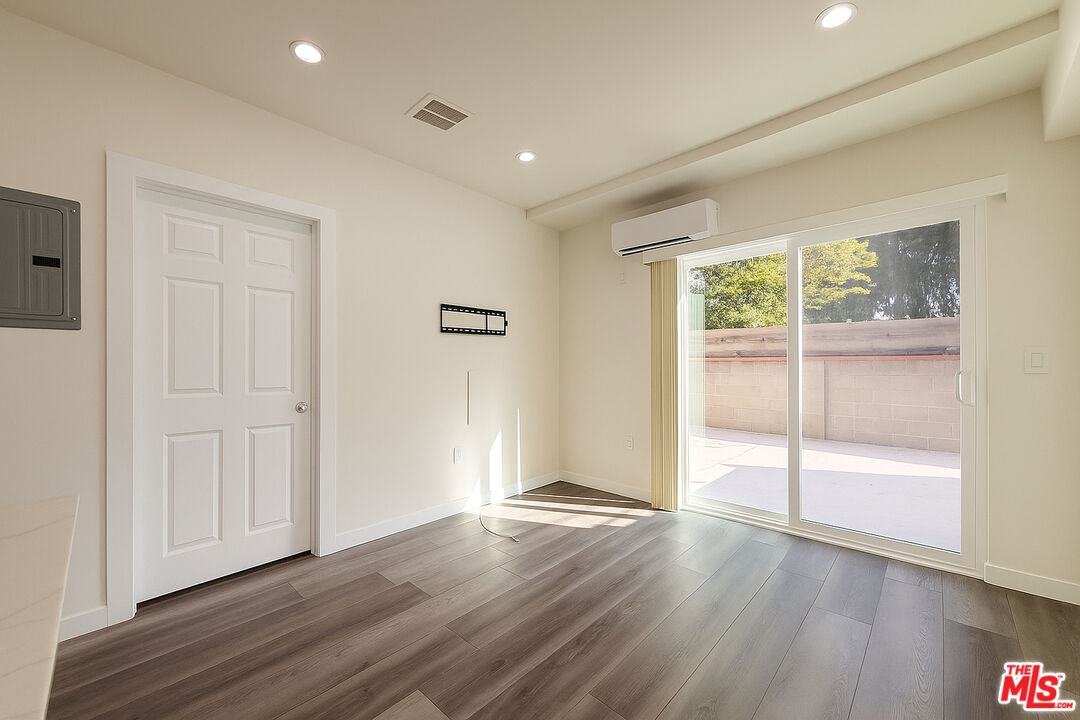 5244 Whitsett Avenue, Unit 1/4 Valley Village, CA 91607 - Photo 8 of 13 an empty room with wooden floor and windows
